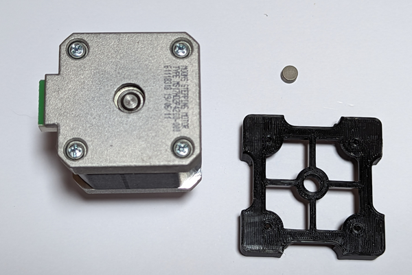 Image showing a Nema17 motor, the 3d printed magnet alignment jig and the magnet